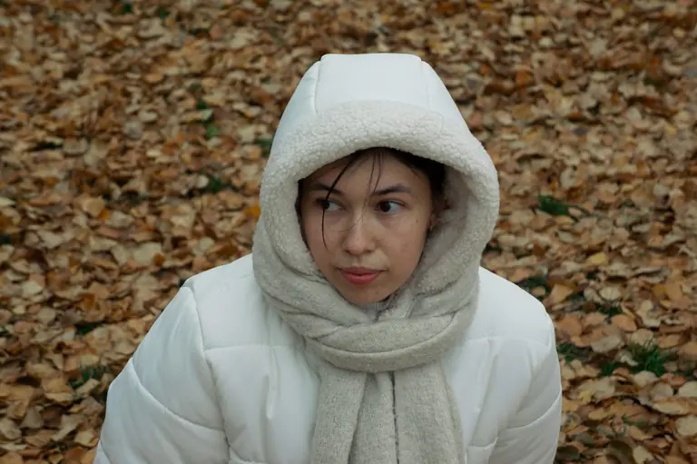 A woman wearing a white coat and a white scarf