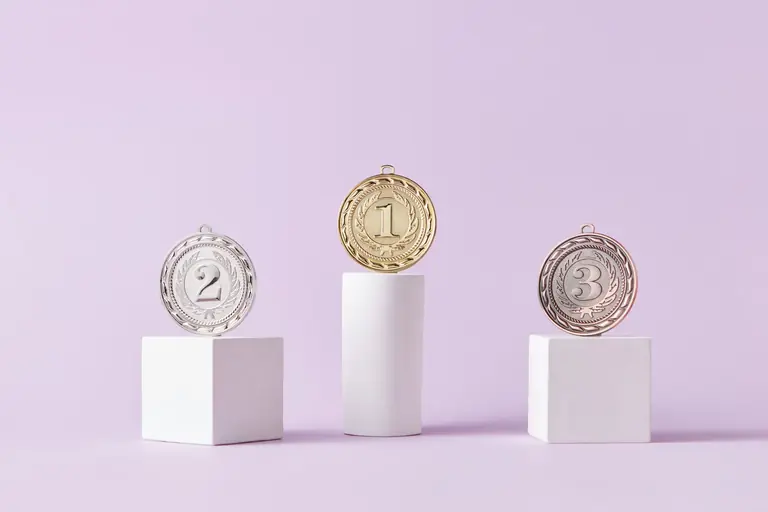 Medals on a podium against a soft pastel background, ideal for awards themes.