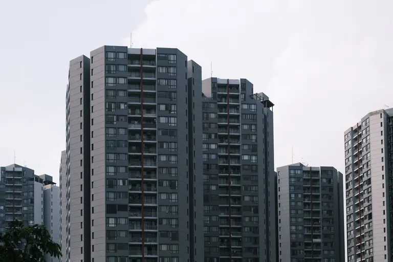 Skyline view of modern high-rise residential buildings against a cloudy sky.